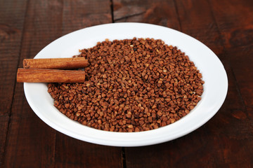 Buckwheat groats in plate on wooden background