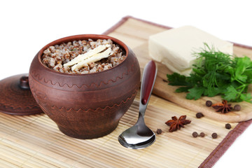 Buckwheat in pot with butter and vegetables closeup