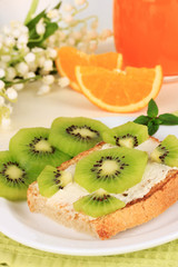 Delicious toast with kiwi on table on light background
