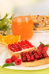 Delicious toast with cranberries on table on light background