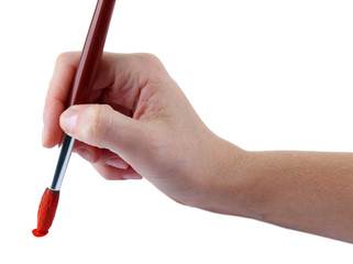 Hand holding brush with red paint isolated on white