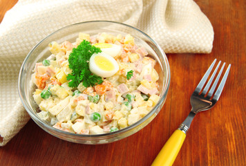 Russian traditional salad Olivier,  on wooden  background