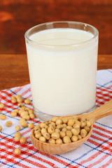 Soy beans with glass of milk on table on wooden background