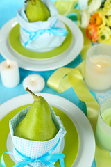 Pears in napkins on plates on wooden table close-up