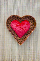 red cloth heart symbol in wicker basket