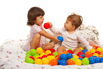 Fototapeta na wymiar Baby boy and toddler girl with balls