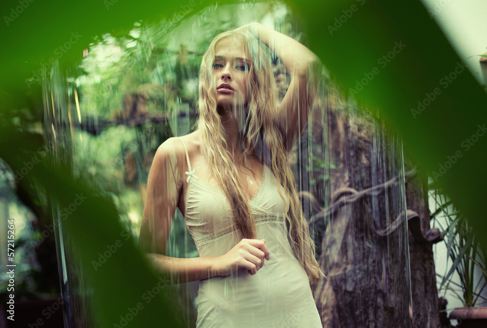 Wall mural Cute teenage lady standing in the rain