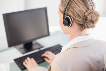 Over shoulder view of blonde call centre agent working