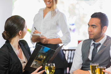 Businesswoman ordering dinner from smiling waitress