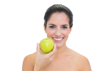 Smiling bare brunette holding green apple