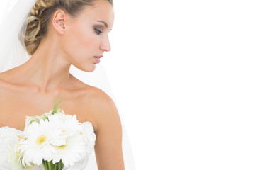 Obraz na płótnie Canvas Thoughtful pretty bride holding a bouquet looking down