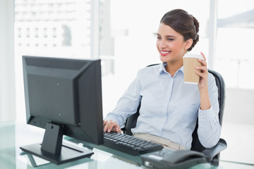 Smiling classy brown haired businesswoman holding a cup of coffe