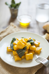 delicious pumpkin gnocchi with sage leaves and olive oil, vegan