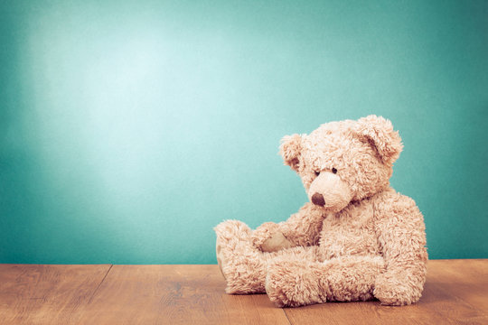 Naklejki Teddy Bear toy alone on wood in front mint green background