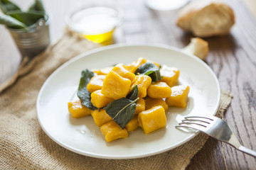 delicious pumpkin gnocchi with sage leaves and olive oil, vegan