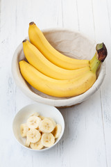 Sliced banana in bowl on wooden table