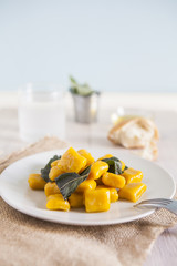 delicious pumpkin gnocchi with sage leaves and olive oil, vegan