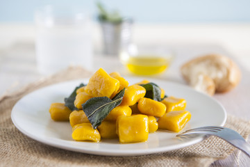 delicious pumpkin gnocchi with sage leaves and olive oil, vegan