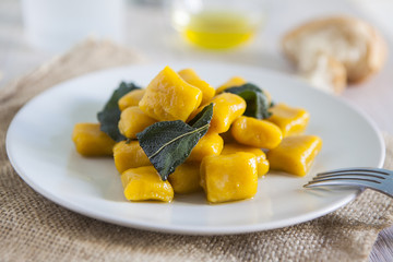 delicious pumpkin gnocchi with sage leaves and olive oil, vegan