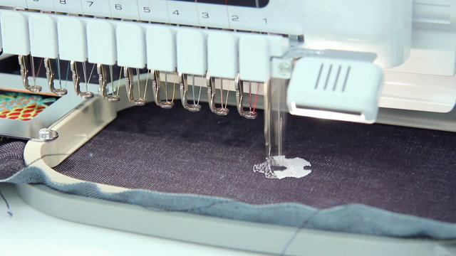 Machine embroidery working a soccer ball on jeans