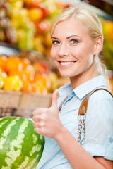 Girl at the shop choosing fruits and vegetables 