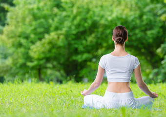 Backview of woman who sits in lotus position zen gesturing