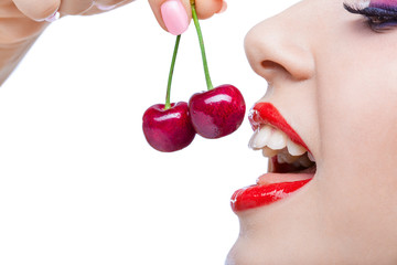 Close up of girl with red lips eating two berries