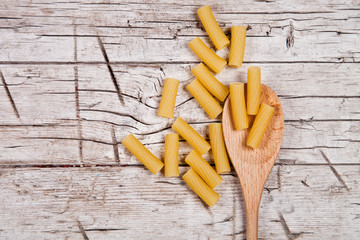 raw macaroni and wooden spoon
