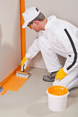 worker waterproofing around the wall and floor