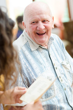 Happy senior man sitting indoor and smiling