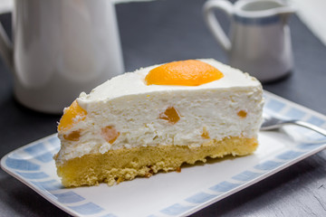mandarin and whipped cream cake at a coffe table