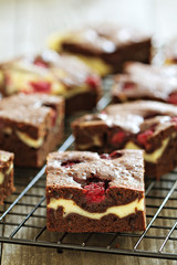 Cheesecake brownies with raspberry on a cooling rack