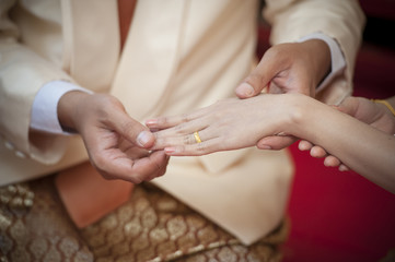 Marry me. Groom put a ring on finger of his lovely wife