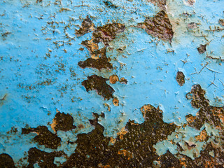 flaking blue paint on wet rusty iron