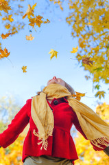 Fototapeta premium Happy woman throwing autumn leaves. Place for text