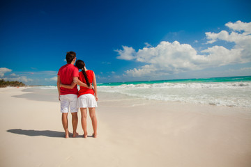 Fototapeta na wymiar Young romantic couple walking on exotic beach in sunny day