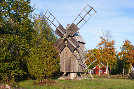 Alte Windmühle vor roten Holzhaus auf Öland, Schweden