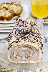 Sweet roll cake on transparent glass cake stand