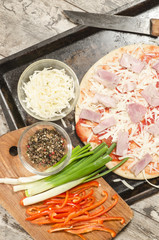 Homemade pizza on baking tray and Ingredients for cooking