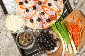Homemade pizza on baking tray and Ingredients for cooking