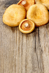Saffron milk cap mushrooms on wooden table. Copy space