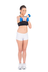 Cheerful fit woman working out with dumbbells