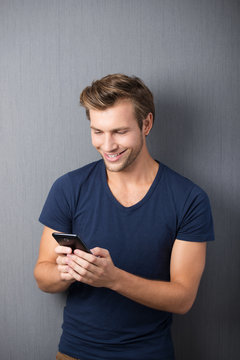 lächelnder mann tippt auf smartphone