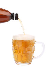 Bottle of beer pouring into a mug.