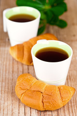 two cups of tea and fresh croissants