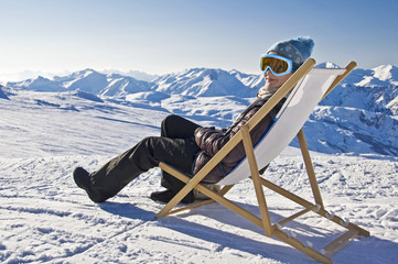 Jeune femme dans une chaise longue au ski