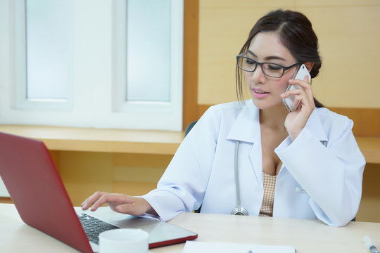 Young doctor woman speaking by phone mobile in her office