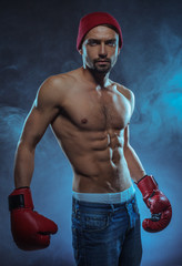 Young athletic boxer in a smoky background