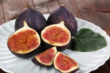 Ripe figs on plate wooden table close-up