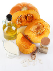 Cut pumpkin with ingredients for cooking isolated on white